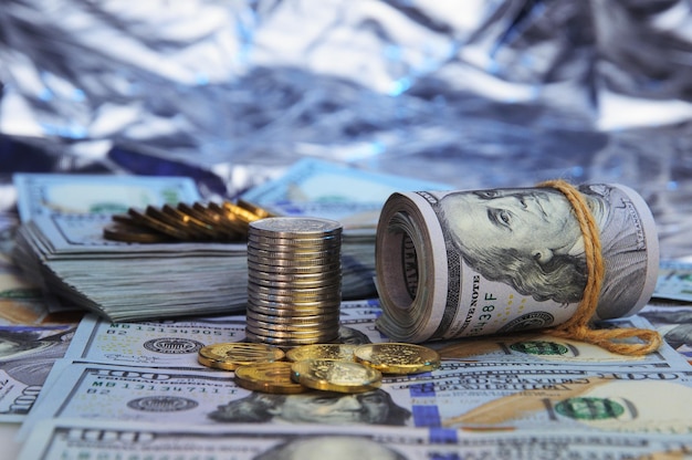 Stacks of coins against the background of hundreddollar bills are scattered throughout the space