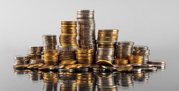 Stacks of coins in reflection on a grey background