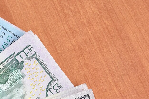 Stacks of many one hundred and fifty dollar bills on wooden background surface close up Flat lay top view Abstract business concept