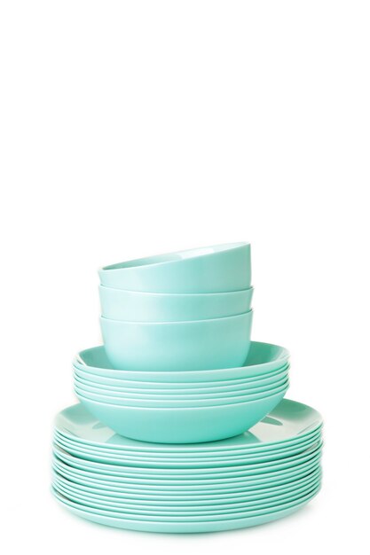 Stacks of mint ceramic dishware on white