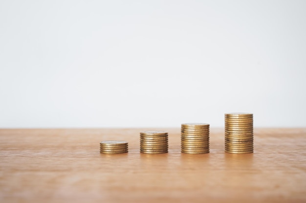 stacks of money coin on wooden desk with white background