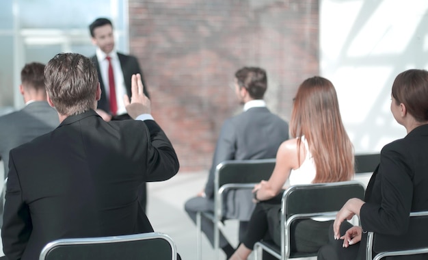 Staff member raises a hand at a conference to answer a question