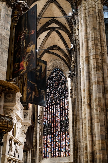 Stained glass windows against the background of the frescoes of the duomo cathedral italy milan