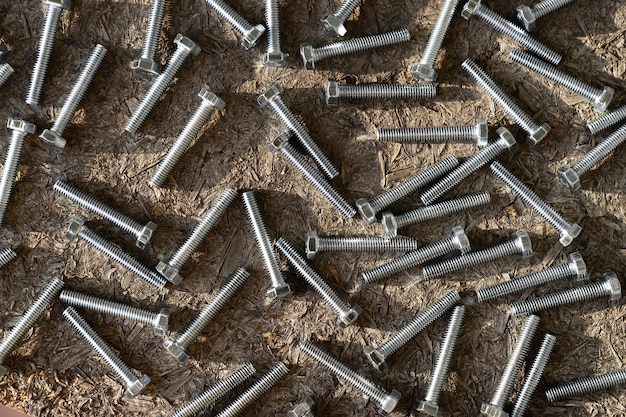 Stainless bolts on wooden background