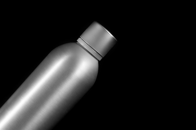 Photo stainless steel bottle on a black background closeup studio photography top view