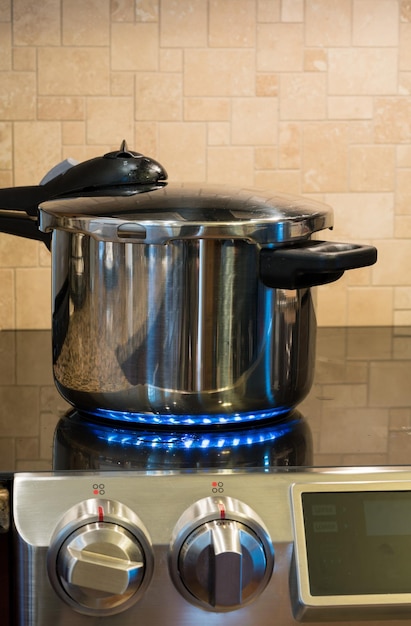 Stainless steel pressure cooker on hob