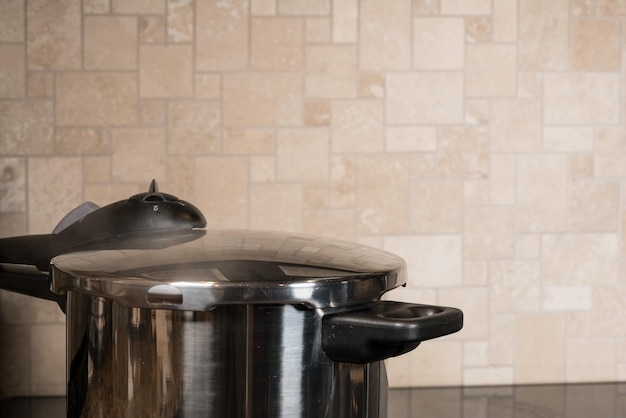 Stainless steel pressure cooker on hob