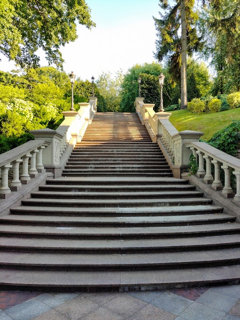 A staircase leading up the mountain with steps made of stone tiles.On her sides there are streetlig