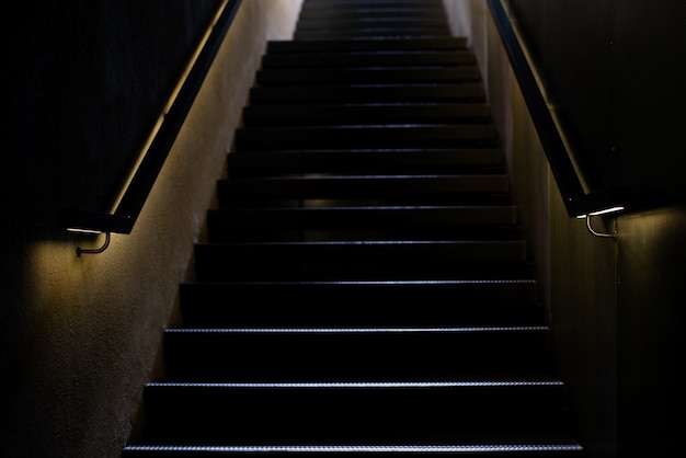  Staircase with illuminated railing in the dark. 