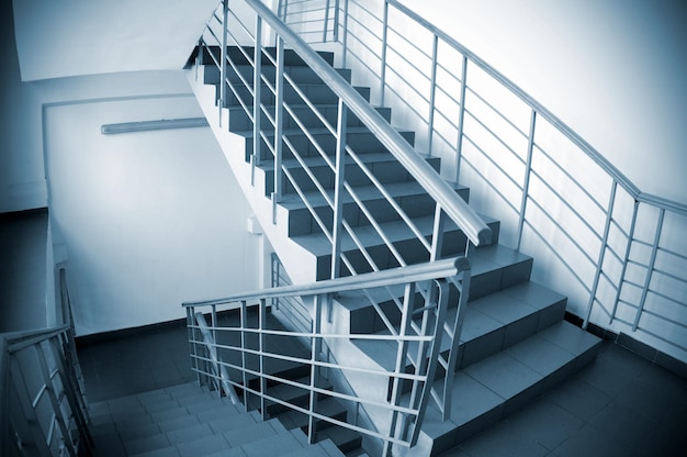 A staircase with a metal handrail and a white background.