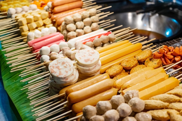 A stall with Asian kebabs at a street food market in Thailand.