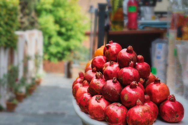 A stall with ripe pomegranates for making juice a street vendor in old Tbilisi Selective focus on fruits Space for text idea for a postcard or travel advertisement