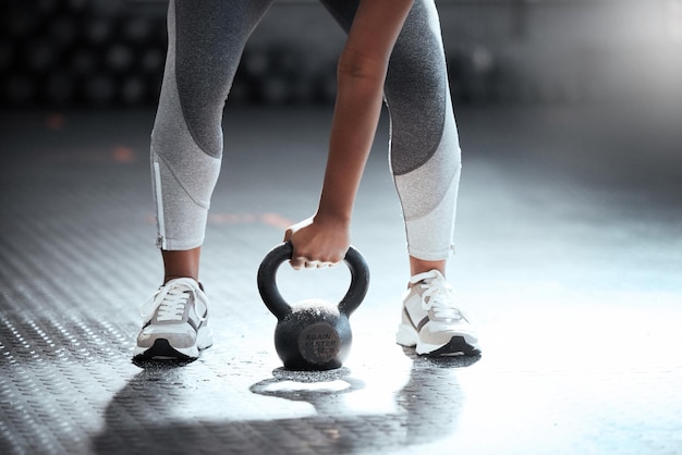 Stance of power Cropped shot of an unrecognizable woman lifting a kettlebell at the gym