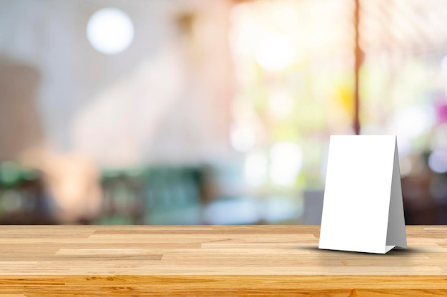 Stand Mock up Menu frame tent card blurred background design key visual layout Empty wood table top with cafe restaurant interior blur background