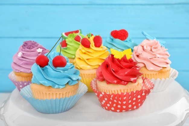 Stand with beautiful cupcakes on blurred background closeup