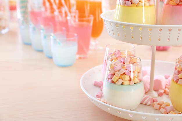 Stand with delicious marshmallow desserts on table closeup