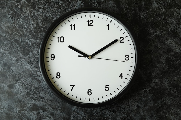 Standard black office clock on black smokey