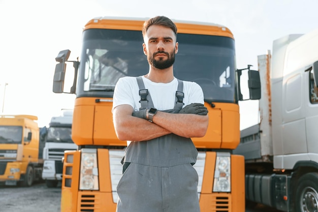 Standing and posing for the camera Man in unifrom doing service for big truck vehicle