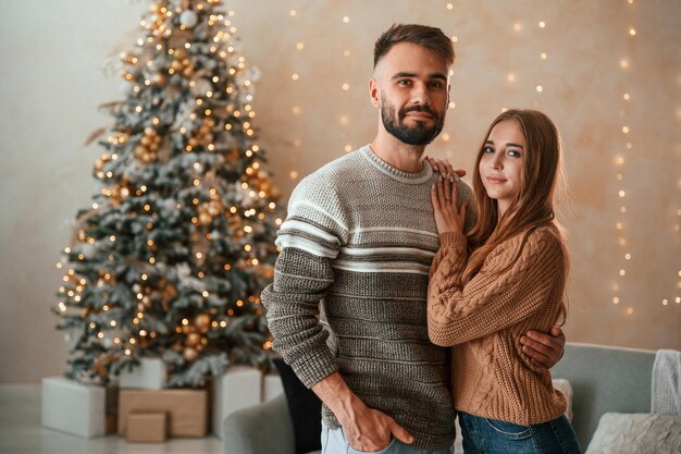 Standing and smiling Lovely young couple are celebrating New Year at home