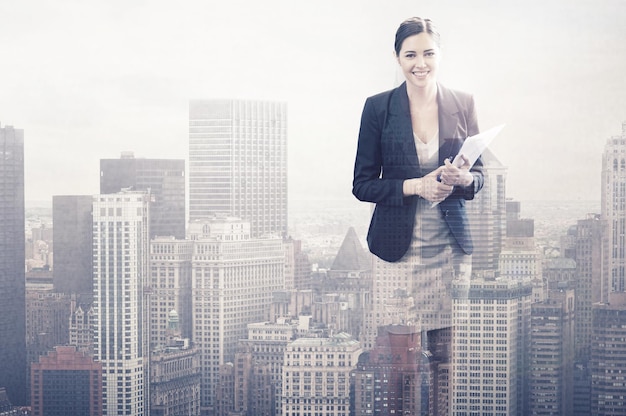 Standing tall in the city Multiple exposure shot of a smiling young businesswoman superimposed on a city