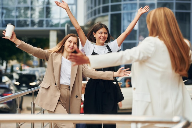 Standing together Women in formal wear is outdoors in the city