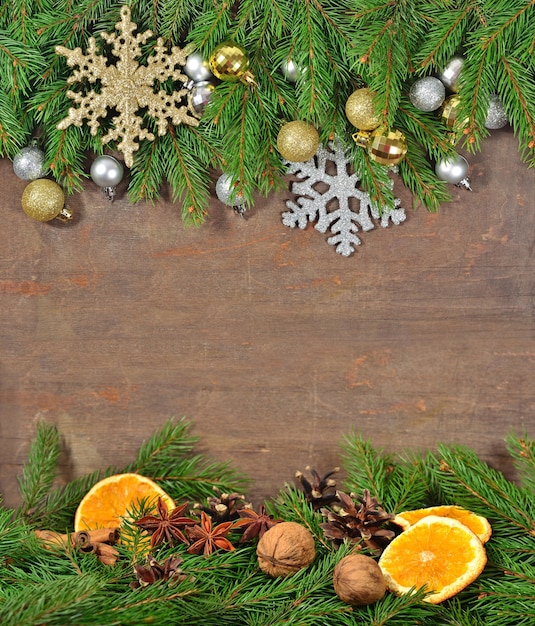 Star anise, nuts, cones, dried oranges and spruse branch on a wooden background