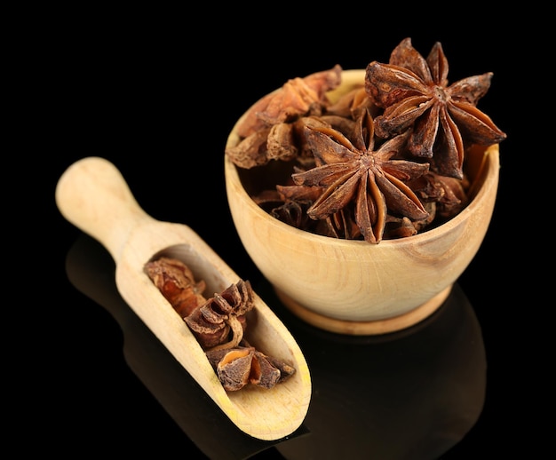 Star anise in wooden bowl isolated on white