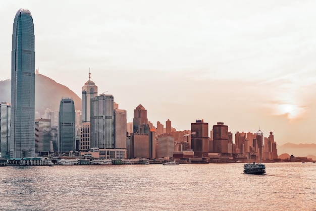 Star ferry at Victoria Harbor in Hong Kong at sundown. View from Kowloon on HK Island.