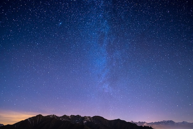 The starry sky on Christmas time and the majestic high mountain range of the Italian French Alps