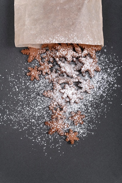 Starshaped gingerbread cookies sprinkled with powdered sugar Top view on gray background Vertical frame