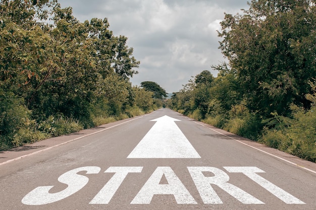 Start text on long country road on top of the mountain with green tree forest and overcast sky Shows a willingness to start something new