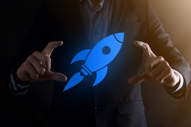 Start up concept with businessman holding abstract digital rocket icon rocket is launching and soar flying.