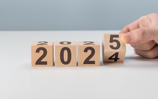 Photo starting new year 2025 flipping of 2024 to 2025 on wooden cube blocks beginning and start of new year 2025 new year life business plan goals target and strategy concept