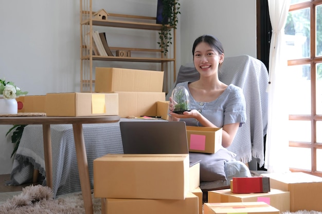 Startup small business entrepreneur SME asian woman packing cloth in box Portrait young Asian small business owner home office online sell marketing delivery SME ecommerce telemarketing concept