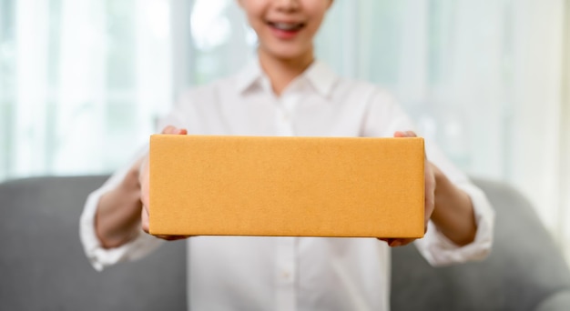 Startup small business woman owner holding packing box to deliver products to customers from online ordering