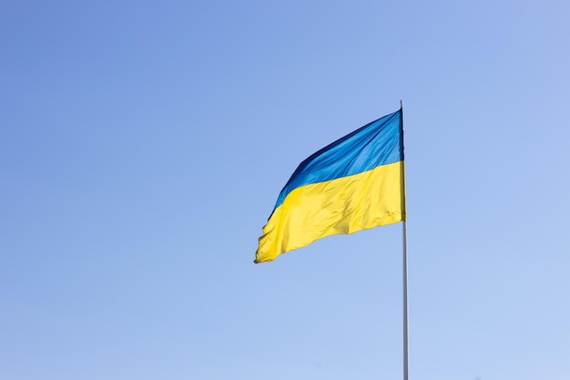 The state flag of Ukraine on a background of blue sky