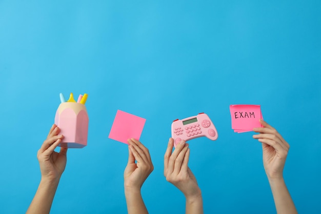 Stationery and exam record in hands on a blue background