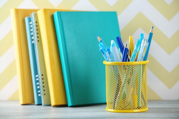 Stationery in metal holder on books background