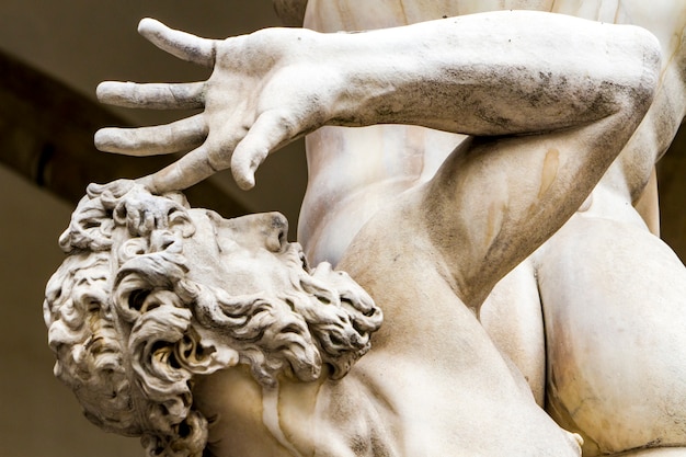 Photo statue abduction of a sabine woman by giambologna from 1583 in the loggia dei lanzi in florence, italy