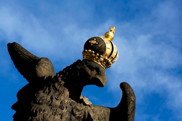 Photo a statue of a eagle with a gold crown on its head