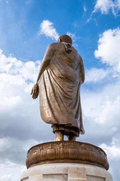 Statue golden buddha standing with blue sky