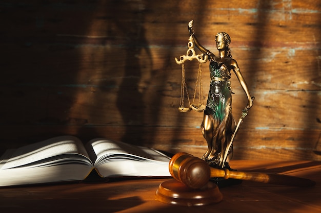 Statue of justice, book and gavel on wooden table. trial concept