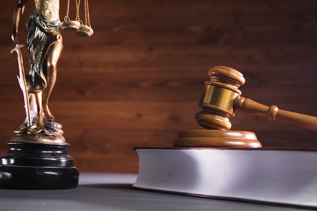 Statue of justice, book and gavel on wooden table