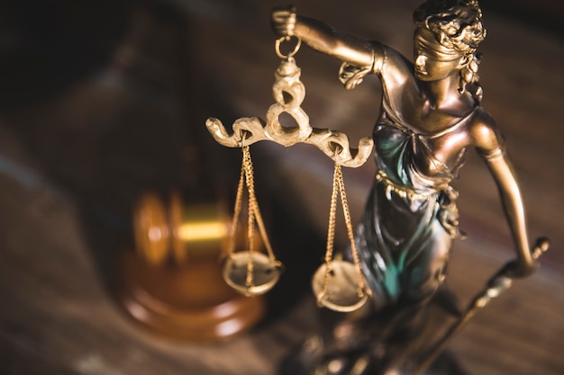 Statue of justice and gavel on wooden table