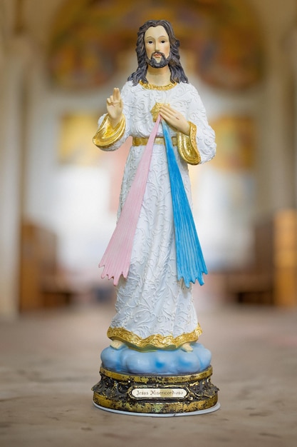 Photo statue of merciful jesus in blurred religious church background