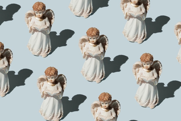 Statues of angels praying on a blue background Christmas pattern