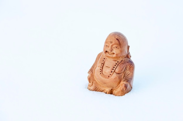 Statuette of Buddha in the snow