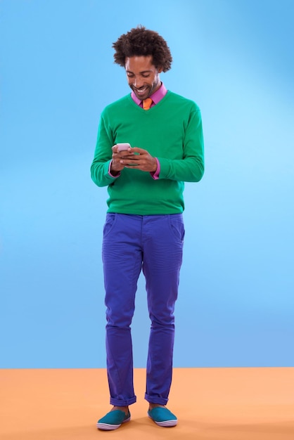 Status update Looking sweet Studio shot of stylish young man talking on the phone against a colorful background