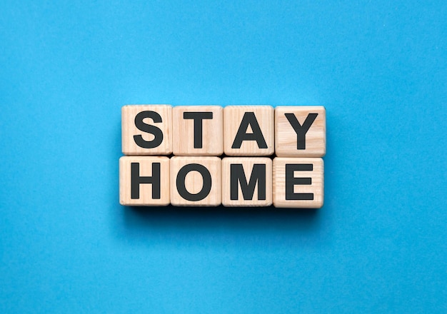 STAY HOME text on wooden blocks, medical concept, blue background