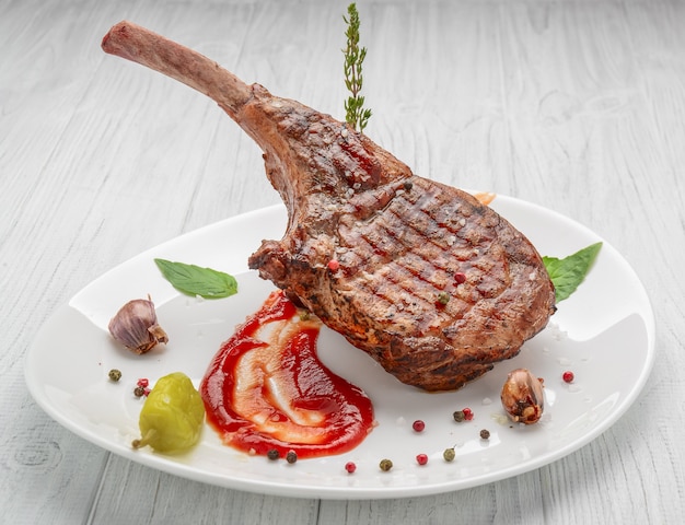 Steak on the bone. tomahawk steak On a white wooden table. Top view.